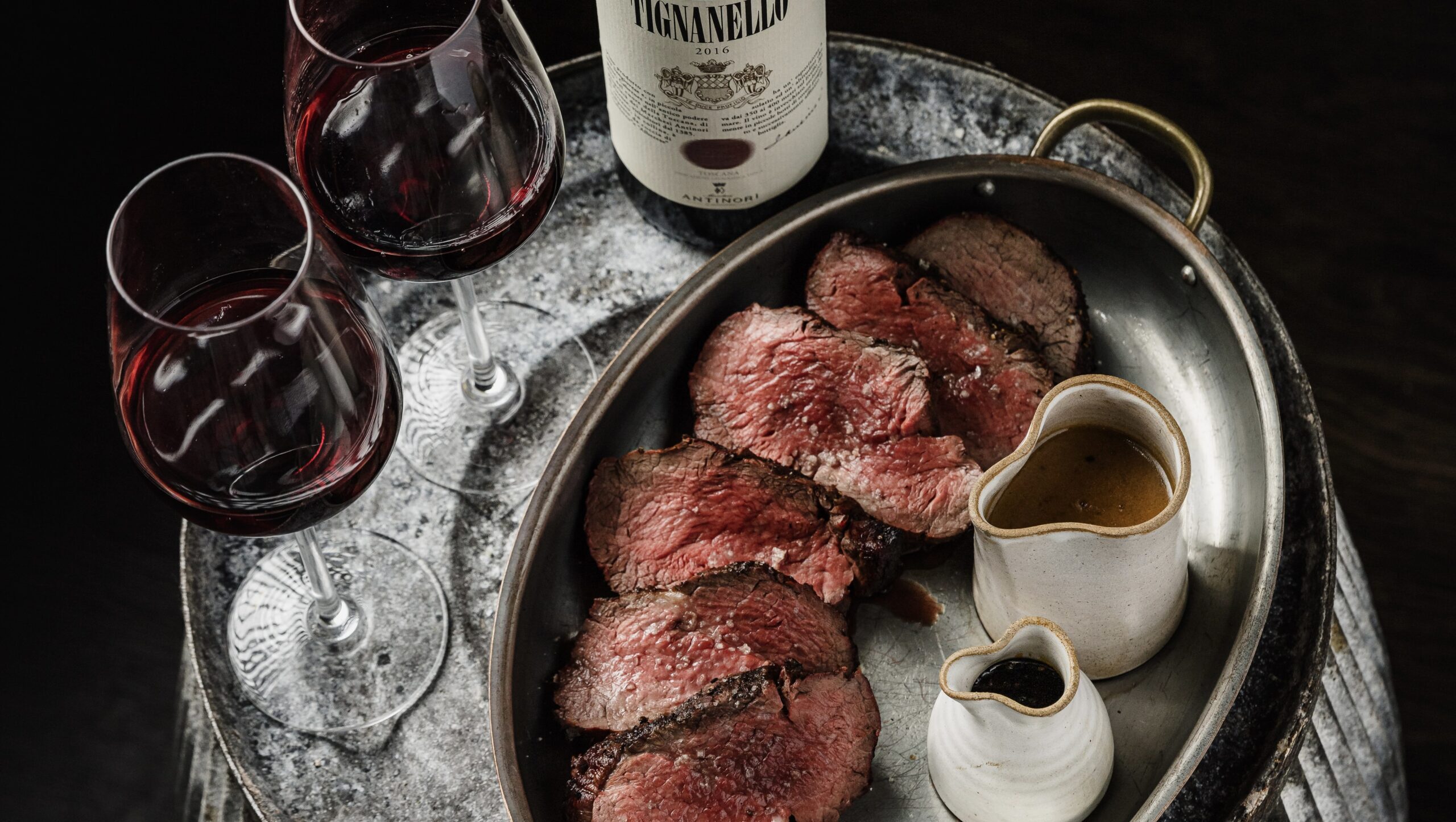 A perfectly cooked steak and a bottle red wine served at pasture.
